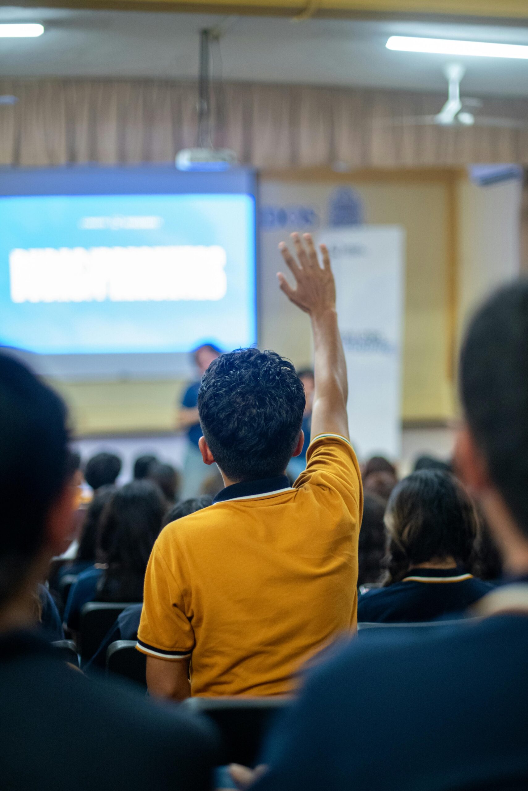 A student raises his hand during a seminar in an educational setting.
