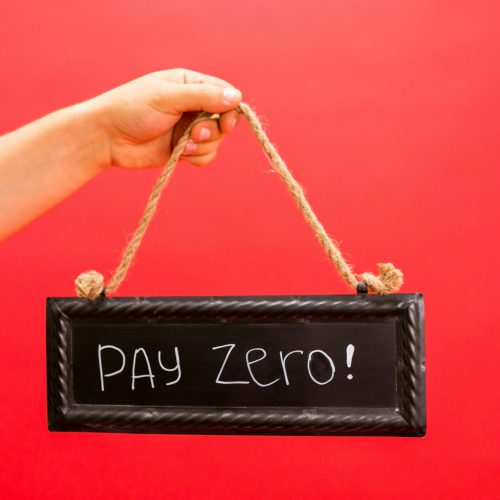 A hand holds a sign displaying 'Pay Zero' on a vibrant red background, emphasizing a free or zero-cost concept.